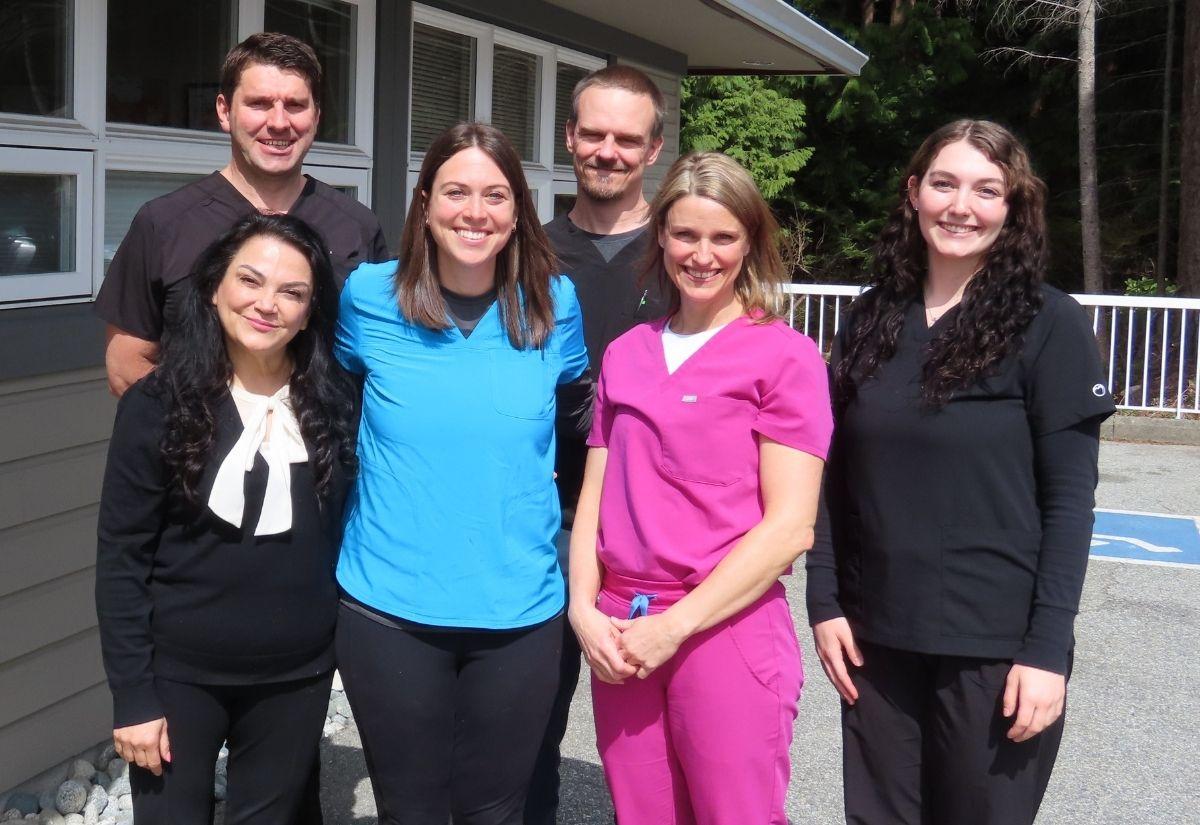 A medical team posing for a photo outside their clinic